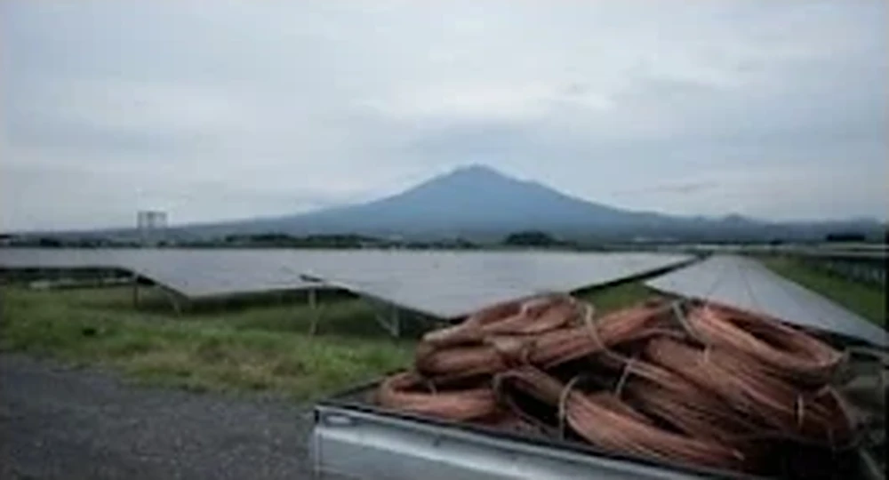 赤城山を望む発電所とトラックに積まれた銅線